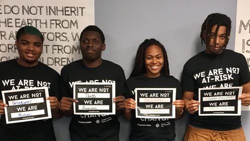 Quavontaye Scott, Marquel Johnson, Foluke Nunn and Brenquavious Johnson hold signs they created for the We Are Not At-Risk social media campaign that seeks to end the use of negative language to describe minority kids. CONTRIBUTED