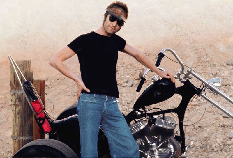 John Lennon poses with a motorcycle (Photo Courtesy of May Pang)