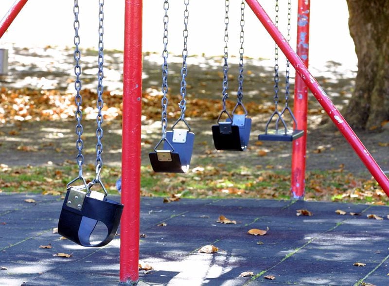 Children's swings are empty at a New Zealand playground.