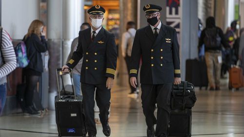 11/23/2020 �  Atlanta, Georgia �Delta Air Lines pilots talk amongst themselves as they walk through the Domestic Terminal at Hartsfield-Jackson Atlanta International Airport in Atlanta , Monday, November 23, 2020.  (Alyssa Pointer / Alyssa.Pointer@ajc.com)