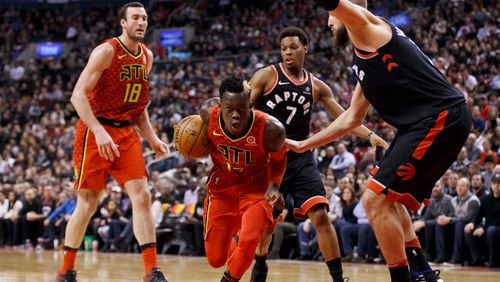 Toronto Raptors' Jonas Valanciunas, right, defends as Atlanta Hawks guard Dennis Schroeder (17) drives to the net during the first half of an NBA basketball game Friday, Dec. 29, 2017, in Toronto. (Cole Burston/The Canadian Press via AP)