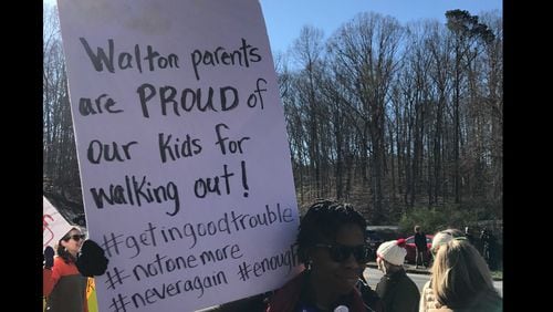 More than 260 Walton High School students walked out of school last week as part of a nationwide protest against gun violence. Dozens of parents and community members stood outside the school with signs to show their support.  Vanessa McCray/AJC