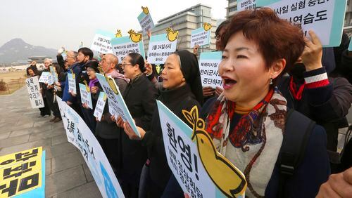 Protesters stage a rally demanding peace on the Korean Peninsula near U.S. Embassy in Seoul, South Korea, Monday, March 12, 2018. Trump administration officials said Sunday there will be no more conditions imposed on North Korea before a first-ever meeting of the two nation's leaders beyond the North's promise not to resume nuclear testing and missile flights or publicly criticize U.S.-South Korean military exercises. The signs read: "Welcome planned summits between North Korea and the United States, South Korea and North Korea." (AP Photo/Ahn Young-joon)