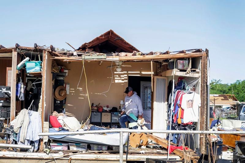 Brian Yazzie helps clean his mother's home after it was damaged by a tornado Tuesday, May 7, 2024 in Barnsdall, Okla. (Mike Simons/Tulsa World via AP)