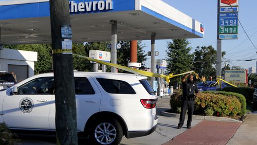 A medical examiner enters the scene of a shooting in the parking lot of a Chevron station at the corner of Monroe Drive and Piedmont Road in Atlanta on Wednesday.