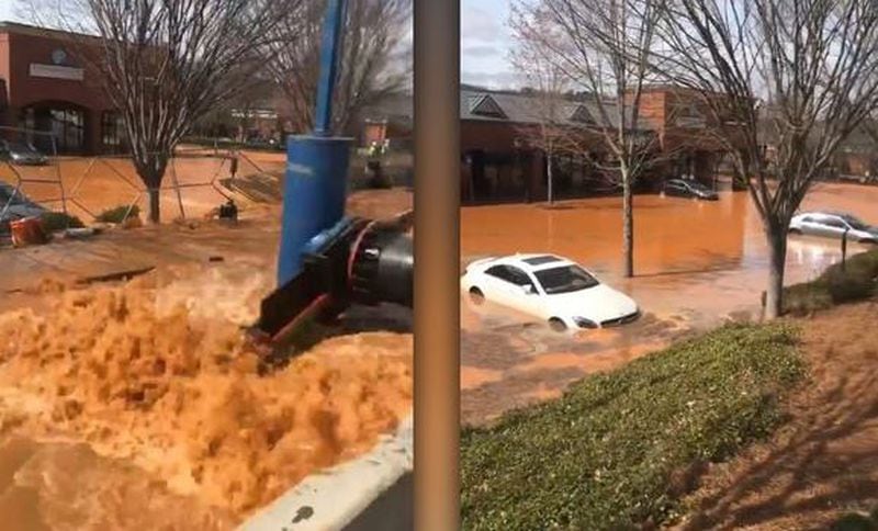A broken water main sent muddy water flooding into this shopping center parking lot near Fariburn and Cascade roads on Monday. Several patrons were unable to reach their cars for hours.