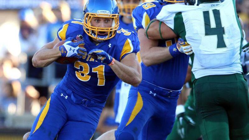 n this Sept. 6, 2014 photo provided by South Dakota State University, SDSU running back Zach Zenner runs against Cal Poly during an NCAA college football game in Brookings, S.D. Zenner, one game away from setting the all-time Football Championship Subdivision record for rushing, is looking to break the FCS record when SDSU faces rival North Dakota State in second-round playoff game Saturday, Dec. 6, 2014 in Fargo. (AP Photo/South Dakota State, Dave Eggen) (The Associated Press)
