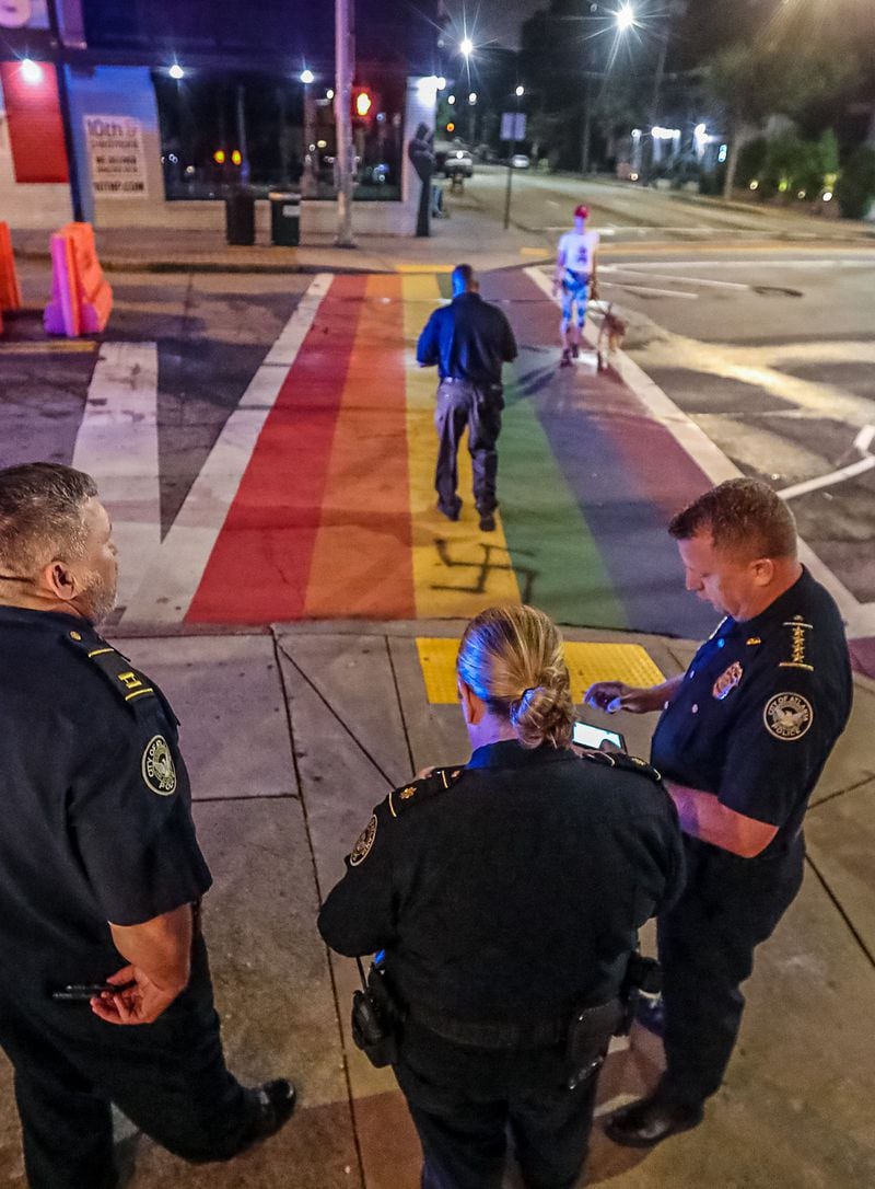 Interim Atlanta police Chief Darin Schierbaum (right) stands with officers at the rainbow crosswalk at 10th Street and Piedmont Avenue after it was vandalized again Friday morning. Schierbaum said police are investigating the act as a hate crime.