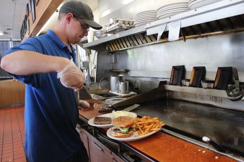 A cook at Ken's Corner Grill in Smyrna puts the finishing touches on an order. (Courtesy of Leo Tochterman)