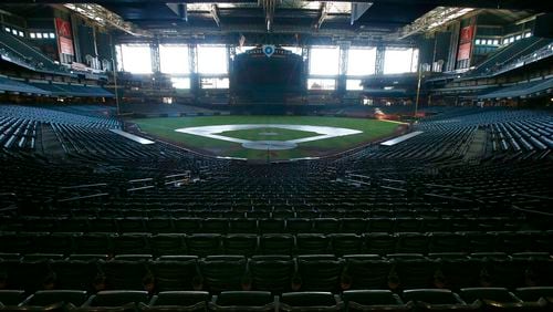 In this Tuesday, April 28, 2020, file photo, a darkened Chase Field, home of the Arizona Diamondbacks of baseball's National League, sits empty.  (AP Photo/Ross D. Franklin, File)