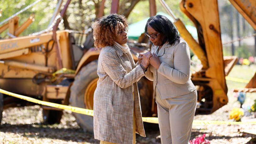 Trina Baynes gets consoled by her cousin, Eartha Sims (left), as they stand in front of the site where Trina's mother should have been buried earlier this month. A broken backhoe sitting at her mother's gravesite at Carver Memorial Gardens has prevented the burial. Wednesday, March 15, 2023.


Miguel Martinez /miguel.martinezjimenez@ajc.com


Miguel Martinez /miguel.martinezjimenez@ajc.com
