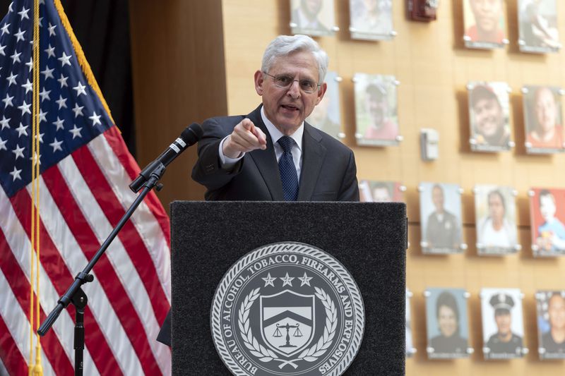 Attorney General Merrick Garland speaks next to a wall with photographs of victims of gun violence during the Inaugural Gun Violence Survivors' Summit at ATF Headquarters in Washington, Tuesday, April 23, 2024. (AP Photo/Jose Luis Magana)
