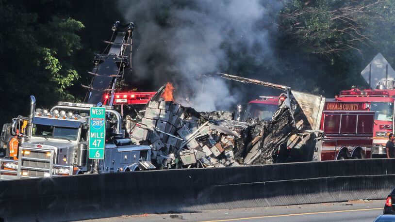 The outer loop of I-285 was shut down for hours Monday in DeKalb County after a tractor-trailer wrecked into two abandoned vehicles in an emergency lane and burst into flames.