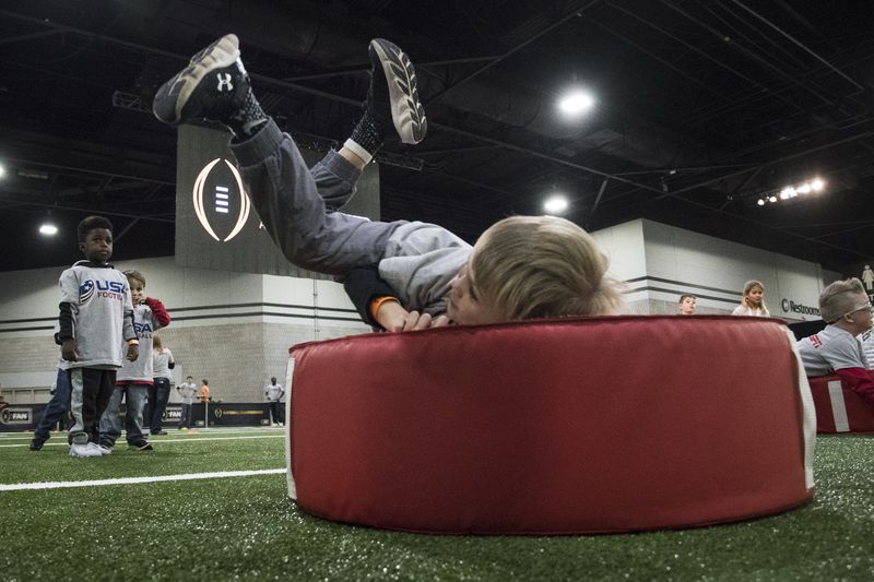 Fans including 5 year old Luke Collins of Fayetteville, Ga., participate at Fan Central in the World Congress Center during College Football Playoff National Championship festivities before the game to be held on January 8, pictured Saturday, Jan. 6, 2017, in Atlanta. More than 100,000 visitors expected for the game and related events over the weekend. (John Amis)