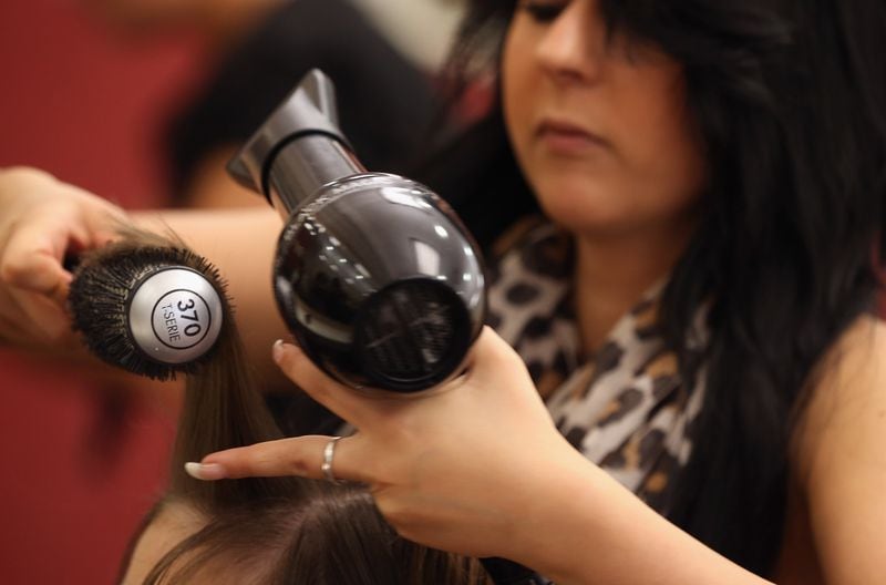 BERLIN, GERMANY - MAY 17:  Full-time hair stylist Sabina tends to a customer at the Cut and Color Friseur Klier hair salon in the Alexa shopping mall on May 17, 2013 in Berlin, Germany. Klier, a German, nationwide chain of hair salons, has taken the initiative in the current minimum wage debates by already introducing in 12 of its salons in eastern Germany the minimum wage that is to be implemented by new federal legislation. Klier has raised wages in the salons by 30% and also raised prices in an expirement to guage customer willingness to pay more. Germany is to implement a minimum wage of EUR 8.50 an hour for hair stylists and barbers nationwide by 2015.  (Photo by Sean Gallup/Getty Images)