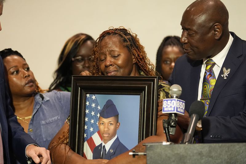 Chantemekki Fortson, mother of Roger Fortson, a U.S. Navy airman, holds a photo of her son during a news conference regarding his death, with Attorney Ben Crump, right, Thursday, May 9, 2024, in Ft. Walton Beach, Fla. Fortson was shot and killed by police in his apartment on May 3, 2024. (AP Photo/Gerald Herbert)