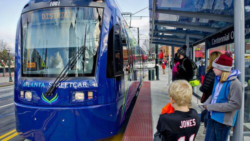 December 31, 2014 Atlanta - Shelby Jones (right) and her brother Dalton wait at the Centennial Olympic Park stop as an Atlanta Streetcar pulls up on Wednesday, December 31, 2014. Each streetcar can hold up to 200 riders. The new service takes about 30 minutes to make a round trip for each of the 12 stops. JONATHAN PHILLIPS / SPECIAL