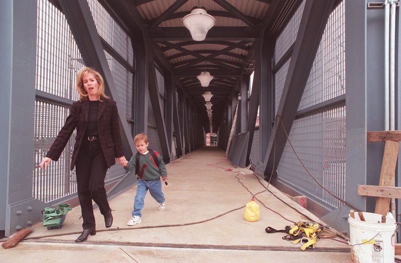 A mother and her son cross the long-awaited pedestrian bridge linking Cumberland Mall with the Cobb Galleria Centre on Jan. 9, 1998.