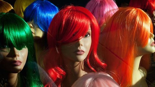 Shop mannequins wearing wigs are displayed in a hair and beauty store in Brixton on February 2, 2012, in London, England.