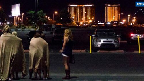 A group of women wait for their ride outside the Thomas & Mack center, which served as a refuge, after the mass shooting at the music festival along the Las Vegas Strip, Monday, Oct. 2, 2017, in Las Vegas. (Yasmina Chavez/Las Vegas Sun via AP)