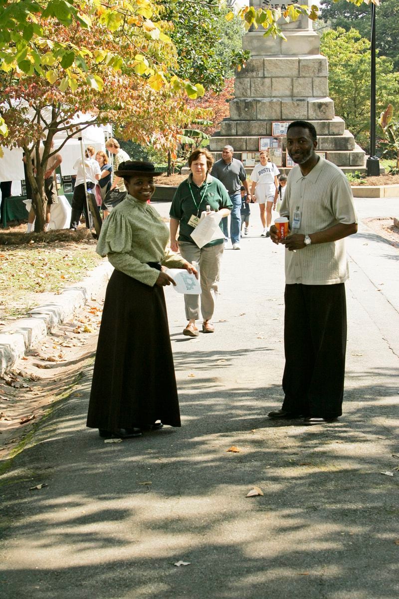 Dr. D.L. Henderson (left) in costume at the Sunday in the Park festival at Oakland Cemetery, speaking with the cemetery's sexton Sam Reed.