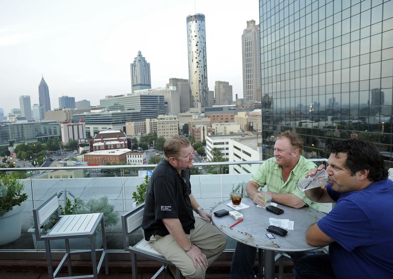 From left, Mike Metzen, Mick Mulcahey, and Mark Bonjovi, all from Los Angeles, Calif., relax at 11 Stories, a bar on the Glenn Hotel’s rooftop.