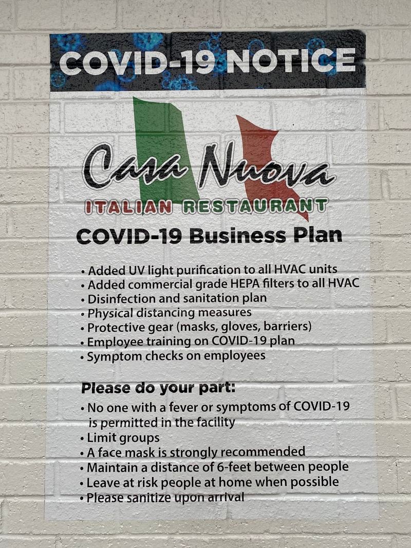 Casa Nuova's COVID-19 safety guidelines are painted on the wall at the entrance to the restaurant. Ligaya Figueras/ligaya.figueras@ajc.com