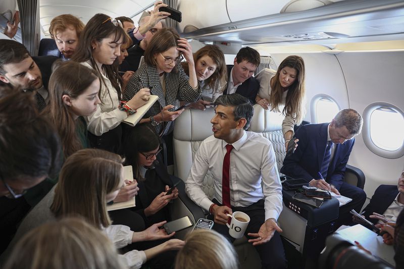 Britain's Prime Minister Rishi Sunak speaks to journalists on board of the plane on the way to Warsaw Chopin airport, Tuesday April 23, 2024. (Henry Nicholls/Pool via AP)