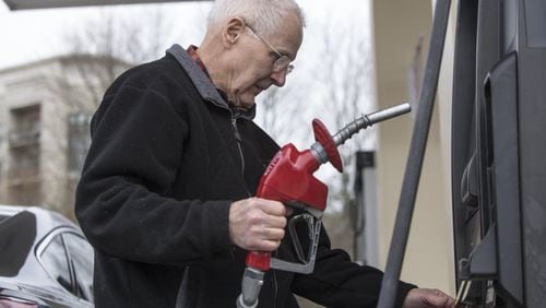 Atlanta drivers are paying more at the pump and prices are likely to rise through through the spring. Here, Harry Haake is about to fill up recently at a Costco gas station in Atlanta. (CASEY SYKES, CASEY.SYKES@AJC.COM)