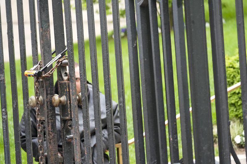 A security officer stands guard behind a locked gate at the Columbia University campus, Tuesday, April 30, 2024, in New York. (AP Photo/Mary Altaffer)