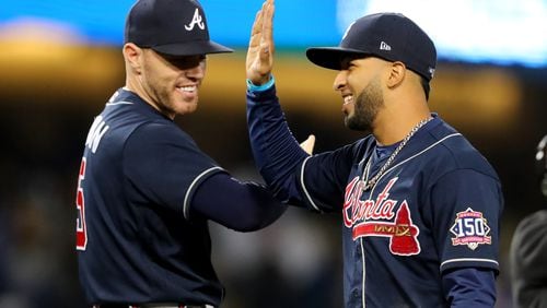 Braves first baseman Freddie Freeman, left, and left fielder Eddie Rosario celebrate their 9-2 win against the Los Angeles Dodgers. Curtis Compton / curtis.compton@ajc.com