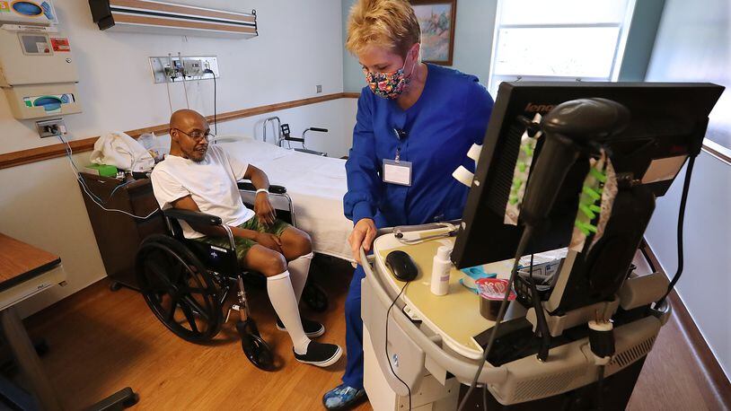 RN Debi Bartlett arrives for a medications administration for patient Rolando Heard in his room at Elbert Memorial Hospital in Elberton, which is pushing patient capacity on Thursday. (Curtis Compton / ccompton@ajc.com)