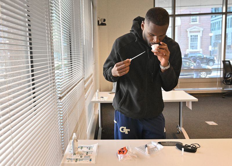 Georgia Tech student Jalen Jenkins collects a saliva sample for PCR COVID-19 test at Georgia Tech’s Economic Development Building on Tuesday, January 4, 2022. (Hyosub Shin / Hyosub.Shin@ajc.com)