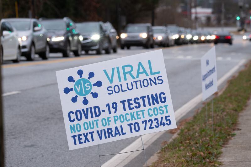 The line of cars to get into the Viral Solutions' drive-thru testing site in Decatur on Tuesday stretched more than a block in each direction on North Druid Hills Road. (Ben Gray for The Atlanta Journal-Constitution)