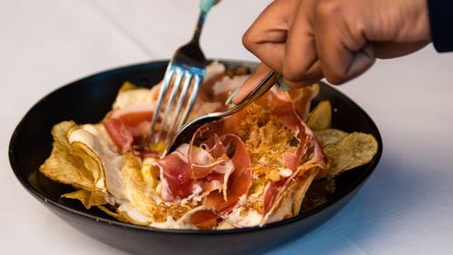 Huevos Bulla is a dish of eggs, house-made potato chips and serrano ham that is mixed tableside. CONTRIBUTED BY HENRI HOLLIS