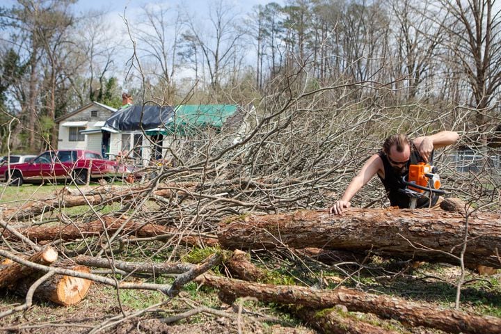Charles Bergeron cuts a fallen tree in his yard left from a tornado, on Friday, March 26, 2021, in Cedartown, Georgia. The storm ripped the roof off of Bergeron house and caused severe damage in several areas throughout the town. No casualties were reported.  CHRISTINA MATACOTTA FOR THE ATLANTA JOURNAL-CONSTITUTION.