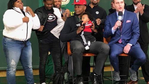 Anthony Edwards hold his 4-month-old nephew Jace as he announces his intention to play for Georgia.