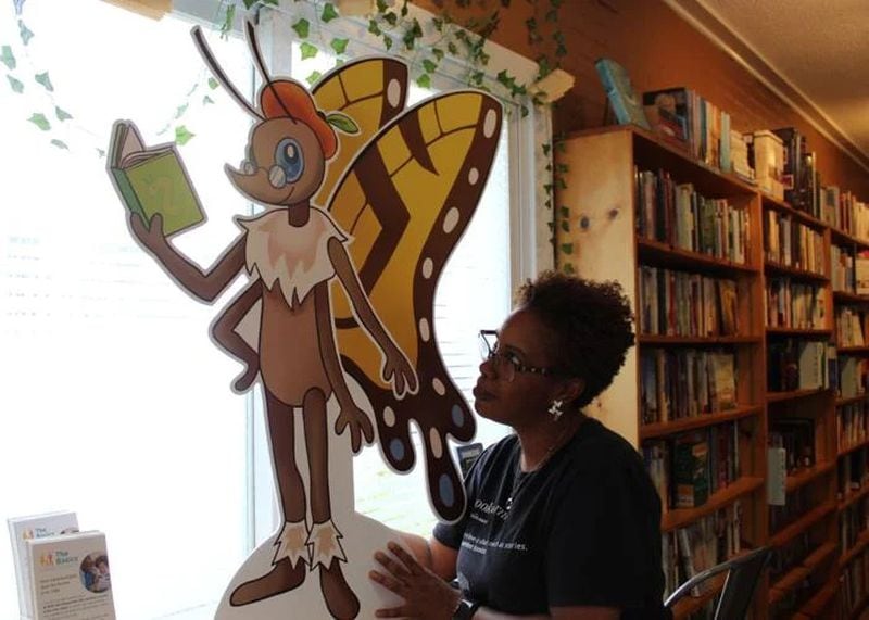 Julia Davis, owner of the Book Worm in Powder Springs, looks at Paige Turner, the mascot of Book Fest. Paige Turner is a butterfly with a peach beret. (Photo Courtesy of Joe Adgie)