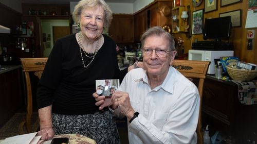 Clyde and Renee Smith hold a photograph of their Japanese medical staff that treated them after they tested positive for the coronavirus. The couple is known for their unwavering optimism. They remained hopeful throughout the experience.STEVE SCHAEFER / SPECIAL TO THE AJC