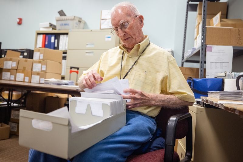 Mac McGowan sorts through some of Muscogee County's 500,000-plus voter registration cards as part of his job keeping its election system up to date and organized. (Nathan Posner for The Atlanta Journal-Constitution)