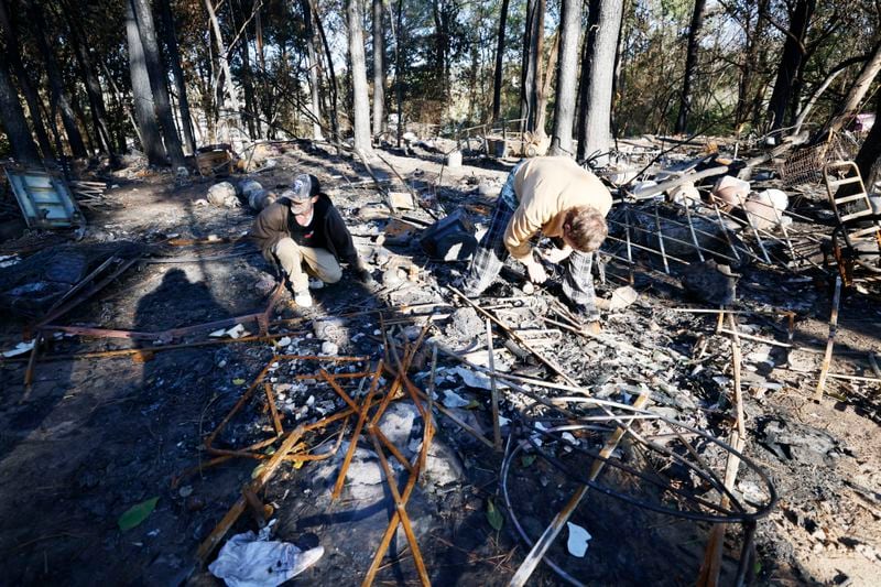 Two men who are homeless, "Tattoo" (left) and Mike (right), removed ashes trying to find valuable items for a friend days after his tent site and many others were destroyed in a brush fire at a Buckhead encampment known as The Hill, in a wooded area near the intersection of Buford Highway and Lenox Road and adjacent to I-85. Both men declined to give their full names.
Miguel Martinez / miguel.martinezjimenez@ajc.com