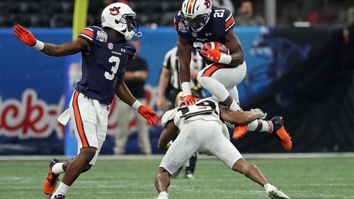 Auburn Tigers running back Kerryon Johnson (21) tries to hurdle UCF Knights defensive back Mike Hughes (19) during the first quarter of the Chick-fil-A Peach Bowl Monday, Jan. 1, 2018, at Mercedes-Benz Stadium in Atlanta.
