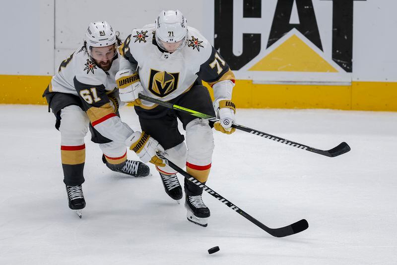 Vegas Golden Knights right wing Mark Stone (61) and center William Karlsson (71) try to control the puck against the Dallas Stars during the second period in Game 7 of an NHL hockey Stanley Cup first-round playoff series, Sunday, May 5, 2024, in Dallas. (AP Photo/Brandon Wade)