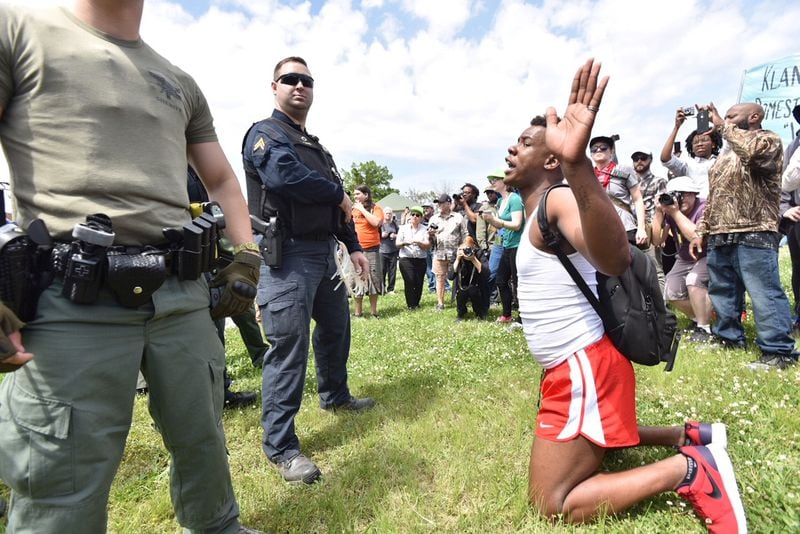 A counterprotester kneels with hands up while facing law enforcement officers Saturday in Newnan, Ga., as neo-Nazis demonstrated. Some counterprotesters were arrested at the event.