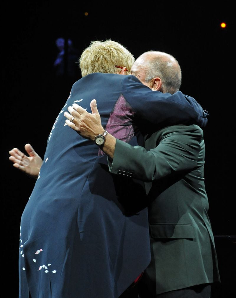 090314 Atlanta --  Elton John (left) and Billy Joel hug each other as they appear on the stage during the Face 2 Face tour Saturday night at Philips Arena. Elton John and Billy Joel, the most successful and longest-running concert pairing in pop history, reunite for their Face 2 Face tour beginning in March, 2009. John and Joel first toured together in 1994, and their most recent outing was a sold-out, 24-date trek in 2003. Elton and Billy open the concerts with a series of duets, playing twin pianos and trading vocals. Each artist then performs a set with his own band. Saturday, March 14, 2009   HYOSUB SHIN / hshin@ajc.com