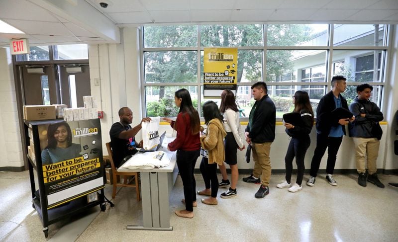 DeKalb County Schools information technology employee Cedrick Greer distributes hot spots to high school students as a part of the Sprint One Million Project at Cross Keys High School on Sept. 13, 2018, in Atlanta. (JASON GETZ/SPECIAL TO THE AJC)
