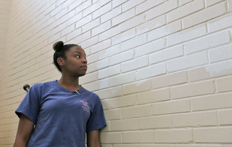 Wesleyan student Kennedy Jones visits the stairway where racist language appeared (now painted over with white paint) and started a racially charged incident at the school. BOB ANDRES /BANDRES@AJC.COM