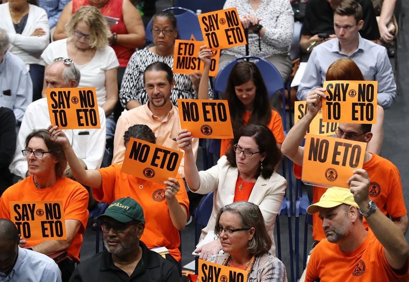 Neighbors of a Cobb County medical equipment sterilization plant hold “NO ETO” signs at a town hall Monday. The forum was held following reports that two Fulton census tracts have high levels of carcinogenic gas emissions. CURTIS COMPTON / CCOMPTON@AJC.COM