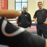 Longtime UGA gymnastics assistant coach Jay Clark, right, shown in this Jan. 5, 2010 photo in Athens, took over as head coach after serving 17 years under legendary coach Suzanne Yoculan. Assistant coach Doug McAvinn, left, is with Clark watching a UGA workout. (Brant Sanderlin/AJC file photo)