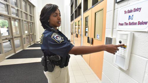 Gwinnet County Public Schools police officer Trakida Maldonado shows a security device at the main entrance of Northbrook Middle School on Wednesday, May 23, 2018. HYOSUB SHIN / HSHIN@AJC.COM